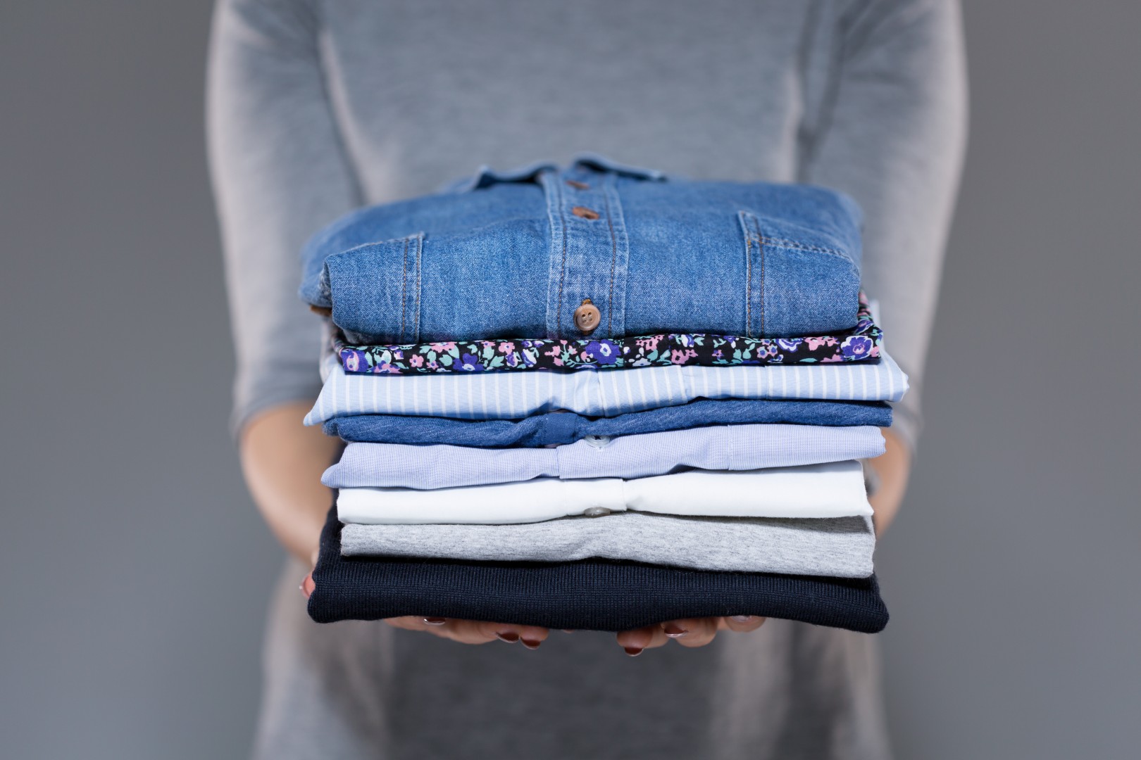 Woman holding folded clothes in hands